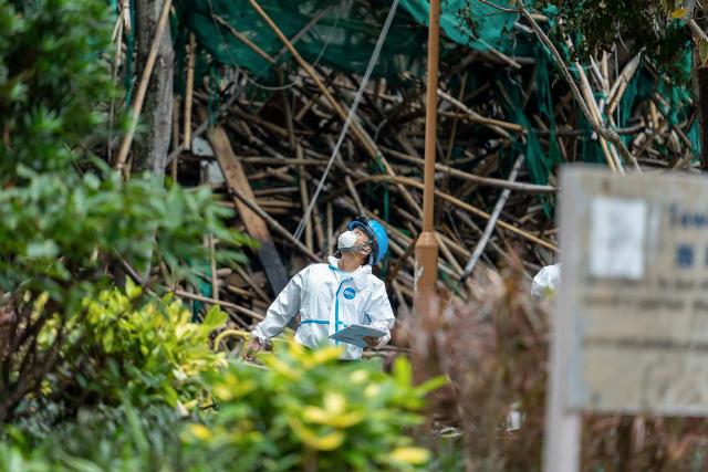 This handout photo released by the Hong Kong Police Force on December 1, 2025 shows officers from the Disaster Victim Identification Unit (DVIU) working after a deadly fire at the Wang Fuk Court residential estate in Hong Kong's Tai Po district. Authorities said on December 1 they have made a total of 13 arrests over Hong Kong's deadliest fire in decades after the blaze killed 151 people last week, a toll that could further rise. (Photo by HONG KONG POLICE FORCE / AFP)