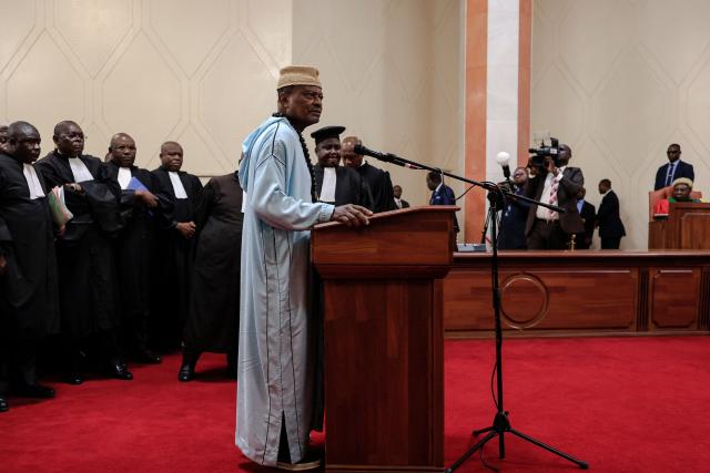 Cameroonian politician Anicet Ekane, director of the MANIDEM political party, is seen with councelors as he attends the appeals hearing at the Constitutional Council, in Yaounde on August 4, 2025. The Cameroonian opposition figure Anicet Ekane passed away Monday morning while in detention in Yaoundé, Valentin Dongmo, vice-president of the African Movement for New Independence and Democracy (Manidem), the party he led, told AFP. (Photo by AFP)