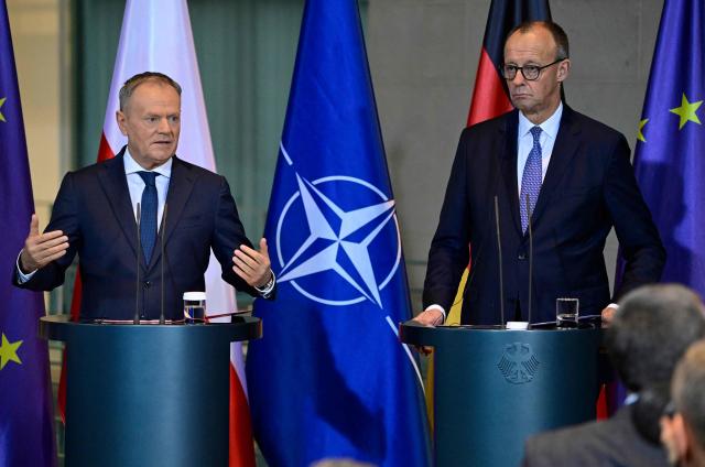 German Chancellor Friedrich Merz (R) and Poland's Prime Minister Donald Tusk address a press conference following talks on December 1, 2025 at the Chancellery in Berlin, Germany. (Photo by John MACDOUGALL / AFP)