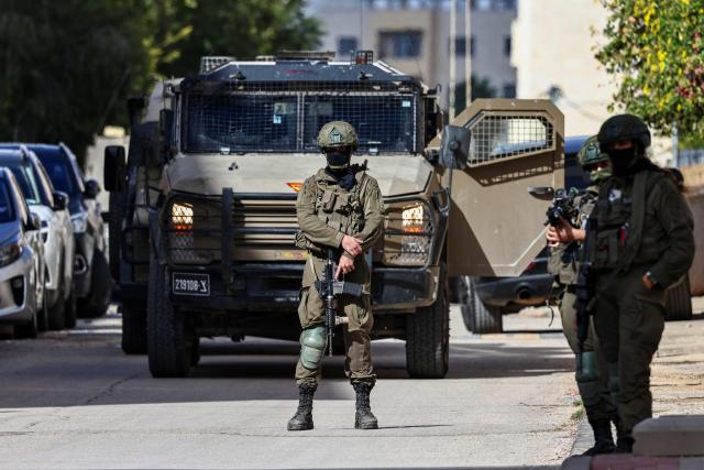 Israeli soldiers take positions during a raid in Ramallah, in the occupied West Bank on December 1, 2025. (Photo by Zain JAAFAR / AFP)