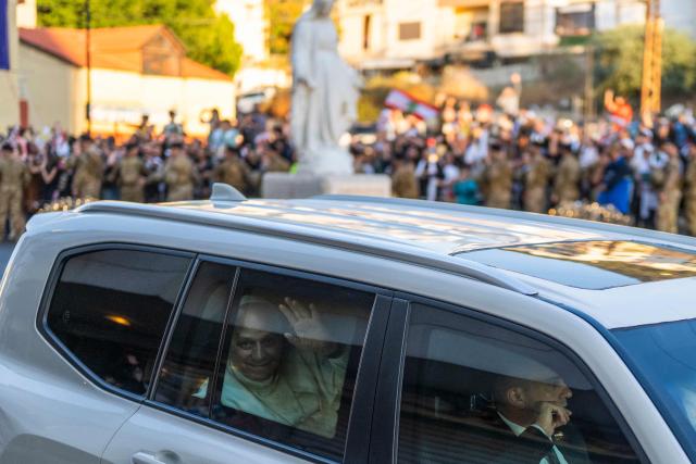TOPSHOT - Pope Leo XIV waves at cheering crowds as his motorcade passes through Jounieh, north of Beirut, on December 1, 2025. Leo prayed for peace in Lebanon and the region on December 1 on day two of his trip to the multi-confessional country, with joyful Lebanese welcoming the pontiff at two famous pilgrimage sites. (Photo by Jewel SAMAD / AFP)