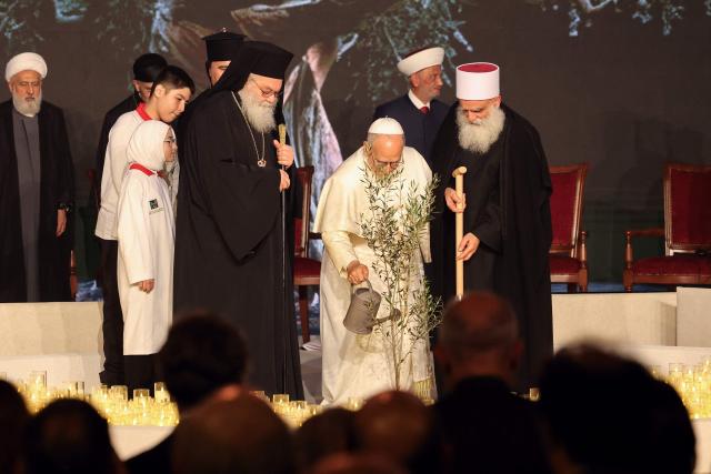 Pope Leo XIV (C) waters an olive tree as he stands next to religious leaders during an ecumenical and inter-religious meeting on Martyrs' Square in central Beirut on December 1, 2025. Pope Leo XIV prayed for peace in Lebanon and the region on December 1 on day two of his trip to the multi-confessional country, with joyful Lebanese welcoming the pontiff at two famous pilgrimage sites. (Photo by anwar amro / AFP)