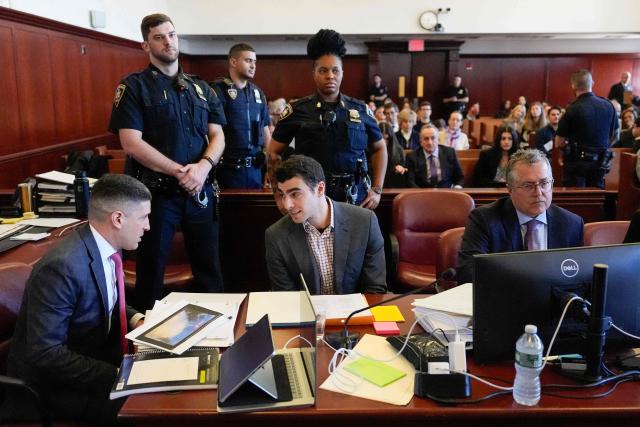 Luigi Mangione (C) sits in the Manhattan Supreme Court during an evidentiary hearing in the murder case of UnitedHealthcare CEO Brian Thompson, in New York, on December 1, 2025. (Photo by Yuki Iwamura / POOL / AFP)