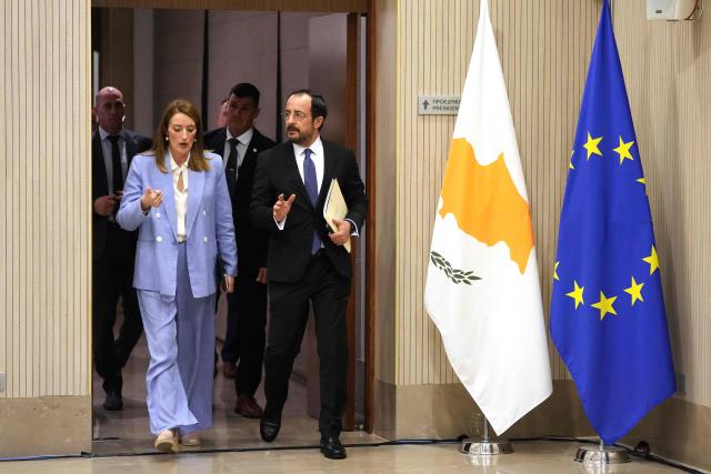 Cyprus' President Nikos Christodoulides (C) walks with European Parliament President Roberta Metsola during their meeting at the Presidential Palace in Nicosia on December 1, 2025. (Photo by Petros Karadjias / POOL / AFP)