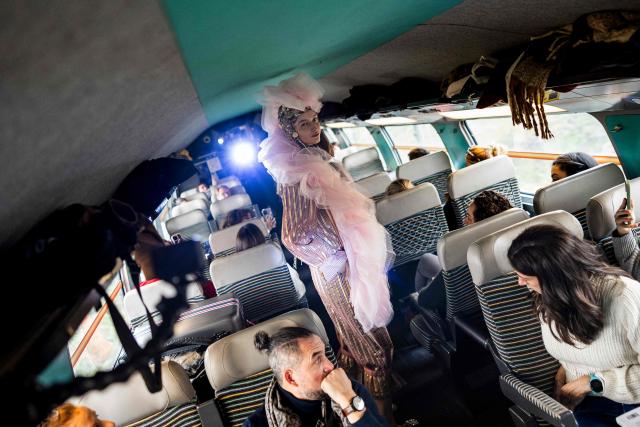 A model presents a creation on a TGV train as part of the "Circular Fashion Week" event on its way from Paris to Lille, on December 1, 2025. Giving visibility to circular fashion players: that is the goal of the first “Circular Fashion Week,” held from the December 1 to 7 in Lille's metropolitan area, with fashion shows, workshops, a professional forum, and a “committed” fashion market. To kick off this week of circular fashion, the first fashion show on a moving train was organised on a Paris-Lille TGV speed train. (Photo by Sameer Al-DOUMY / AFP)