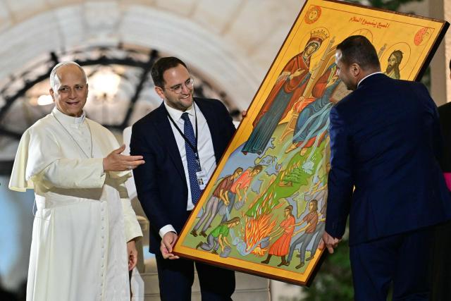 Pope Leo XIV receives a gift during a gathering with youths at the Maronite Patriarchate in Bkerke, north of the capital Beirut, on December 1, 2025. Leo prayed for peace in Lebanon and the region on December 1 on day two of his trip to the multi-confessional country, with joyful Lebanese welcoming the pontiff at two famous pilgrimage sites. (Photo by Giuseppe CACACE / AFP)