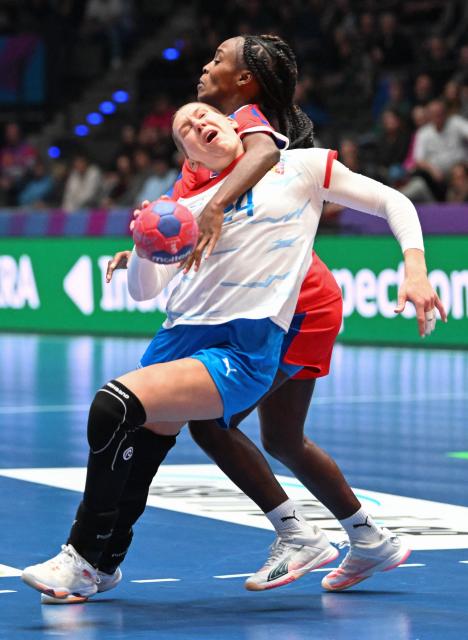 Czech Republic's #24 Eliska Desortova (front) and Cuba’s #17 Angela Amoros vie for the ball during the preliminary round Group G match between Czech Republic and Cuba during the IHF Women's Handball World Championship in Stuttgart, southwestern Germany on December 1, 2025. (Photo by THOMAS KIENZLE / AFP)