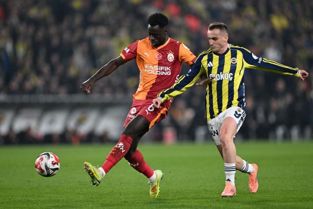 Fenerbahce'S Turkish forwards #9 Kerem Akturkoglu (R) fights for the ball with Galatasaray's Colombian defender #6 Davidson Sanchez during the Turkish Super lig football match between Fenerbahce and Galatasaray at the Fenerbahce Sukru Saracoglu stadium in Istanbul, on December 1, 2025. (Photo by Ozan KOSE / AFP)