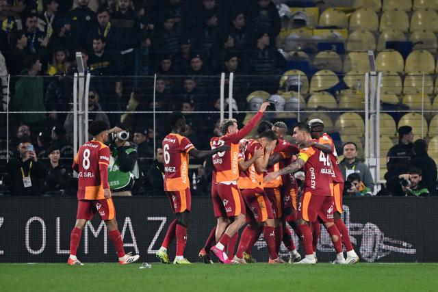 Galatasaray's celebrate scoring their team's first goal during the Turkish Super lig football match between Fenerbahce and Galatasaray at the Fenerbahce Sukru Saracoglu stadium in Istanbul, on December 1, 2025. (Photo by Ozan KOSE / AFP)