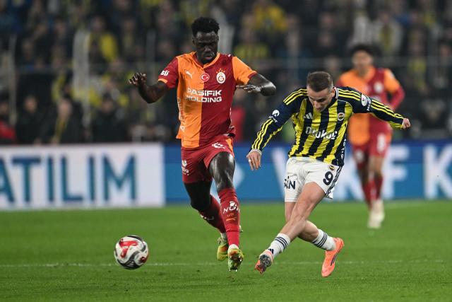 Fenerbahce's Turkish forwards #09 Kerem Akturkoglu (R) vies for the ball with Galatasaray's Colombian defender #06 Davidson Sanchez during the Turkish Super lig football match between Fenerbahce and Galatasaray at the Fenerbahce Sukru Saracoglu stadium in Istanbul, on December 1, 2025. (Photo by Ozan KOSE / AFP)