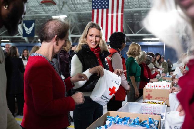 Jennifer Hegseth, wife of Secretary of Defense Pete Hegseth, helps make care packages for deployed members of the US military during an American Red Cross holiday event with military families at Joint Base Andrews in Maryland, December 1, 2025. (Photo by SAUL LOEB / AFP)