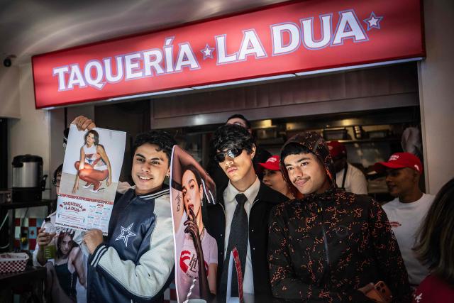 Fans of British-Albanian singer-songwriter Dua Lipa pose for pictures during the opening of the pop-up taco shop, Taqueria La Dua, in Mexico City on December 1, 2025. The pop-up celebrates Dua Lipa's arrival in Mexico, the last stop on her international Radical Optimism Tour. (Photo by Carl de Souza / AFP)
