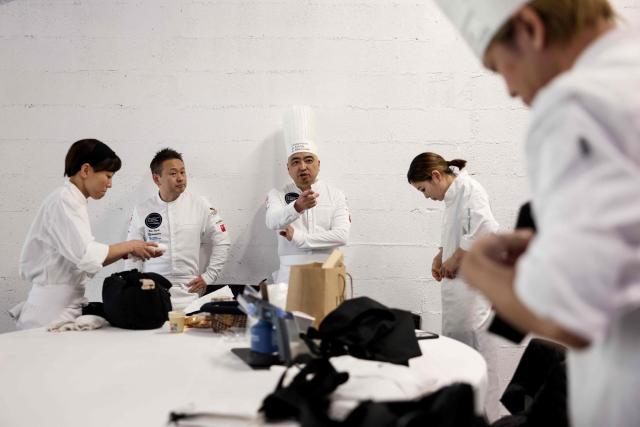 Japanese chef Kota Suzuki (L) representing Monaco, Japanese chef Seigo Ishimoto (C) representing Japan and Japanese chef Sho Ito (R) representing Japan, react prior to the start of the 16th Edition of the 2025 Pate-Croute World Championship, in Lyon, central-eastern France, on December 1, 2025. (Photo by Alex MARTIN / AFP)