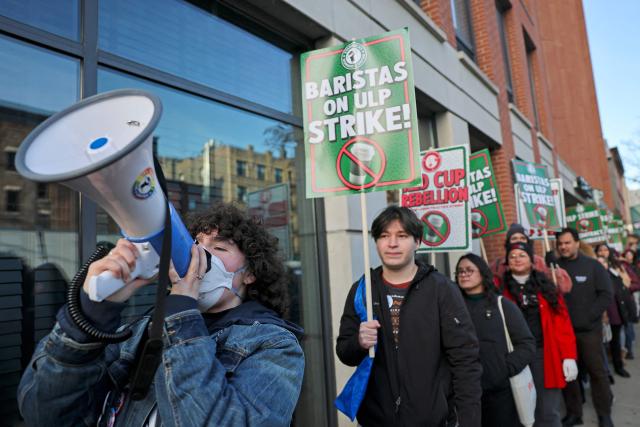 Striking Starbucks workers walk the picket line in New York on December 1, 2025. (Photo by ANGELA WEISS / AFP)