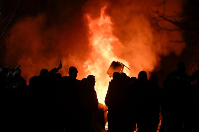 Protesters burn trash cans during an anti-government protest in Sofia on December 1, 2025. Tens of thousands of people held anti-government protests in Bulgaria on Monday, widening an anti-corruption movement sweeping the European Union's poorest country as it prepares to adopt the euro. (Photo by Nikolay DOYCHINOV / AFP)