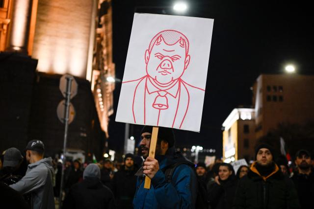 A protester holds a placard depicting Bulgarian politician Delyan Peevski during an anti-government protests in Sofia on December 1, 2025. Tens of thousands of people held anti-government protests in Bulgaria on Monday, widening an anti-corruption movement sweeping the European Union's poorest country as it prepares to adopt the euro. (Photo by Nikolay DOYCHINOV / AFP)