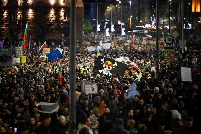 A protester holds a placard bearing the logo of the popular Japanese manga One Piece, a symbol adopted by Gen Z protest movements worldwide, during an anti-government protest in Sofia on December 1, 2025. Tens of thousands of people held anti-government protests in Bulgaria on Monday, widening an anti-corruption movement sweeping the European Union's poorest country as it prepares to adopt the euro. (Photo by Nikolay DOYCHINOV / AFP)
