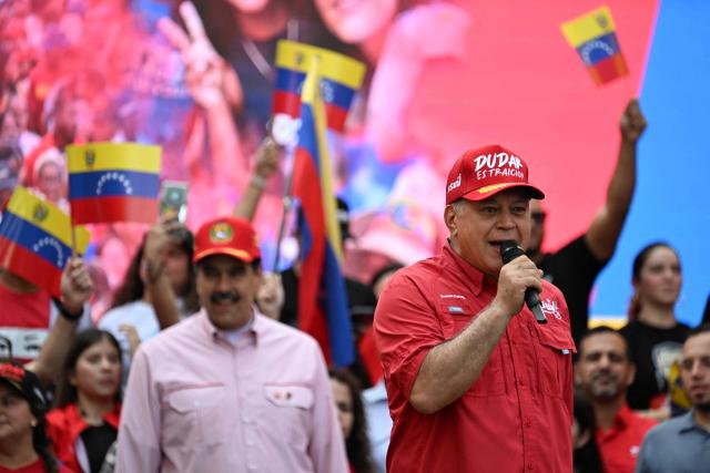 Venezuela's Minister of Interior Relations, Justice and Peace, Diosdado Cabello, speaks in front of Venezuelan President Nicolas Maduro in community committees organized by the government during a rally in Caracas on December 1, 2025. Venezuela does not want "a slave's peace," President Nicolas Maduro told thousands of supporters during a rally, referring to a US military deployment he said has been "testing" his country for 22 weeks. (Photo by Juan BARRETO / AFP)