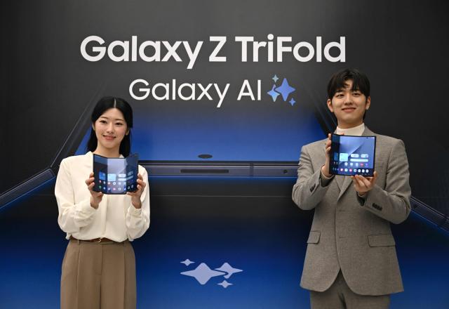 Promoters show Samsung Galaxy Z TriFold smartphones during a launch event at a Samsung store in Seoul on December 2, 2025. Samsung Electronics unveiled its first tri-fold phone on December 2, as the conglomerate rushes to show it can keep pace with rivals in generative AI. (Photo by Jung Yeon-je / AFP)