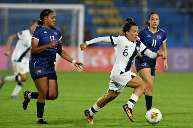 Guatemala's midfielder #06 Maria Contreras evades Bermuda's midfileders #17 Khyla Brangman and #11 Eva Frazzoni during the Women Concacaf W qualifiers football match between Guatemala and Bermuda at Manuel Felipe Carrera stadium in Guatemala City on December 1, 2025. (Photo by JOHAN ORDONEZ / AFP)