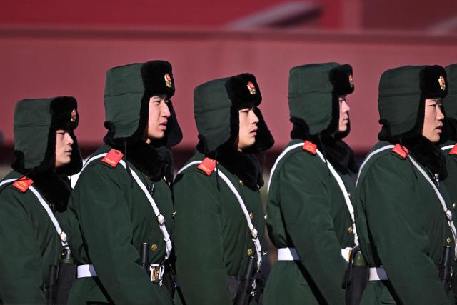 Paramilitary policemen march at Tiananmen Square in Beijing on December 2, 2025. (Photo by Pedro PARDO / AFP)