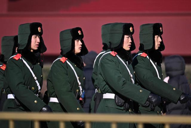 A security personnel stands guard at Tiananmen Square in Beijing on December 2, 2025. (Photo by Pedro PARDO / AFP)
