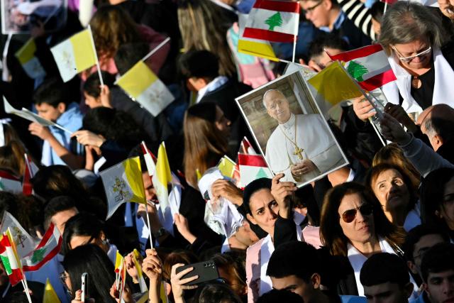 People gather outside the Sisters of the Cross Hospital in Beirut's northern suburb of Jdeideh before the visit of Pope Leo XIV on December 2, 2025.  (Photo by Andreas SOLARO / AFP)