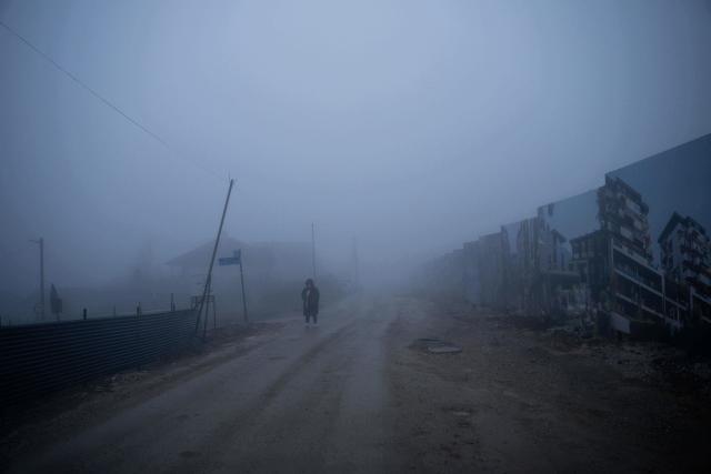 TOPSHOT - A resident walks through thick smog in Pristina on December 2, 2025. (Photo by Armend NIMANI / AFP)