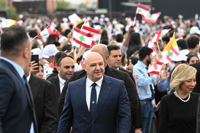 Lebanon's President Joseph Aoun (C) and his wife Nehmat Aoun (R) arrive to attend Pope Leo XIV delivering the homily during a mass at Beirut's waterfront on December 2, 2025. The pontiff arrived from Turkey on November 30, on his inaugural visit abroad as Pope and brought a message of hope, particularly to young people in Lebanon, whose faith in their beleaguered country has dwindled. (Photo by JOSEPH EID / AFP)