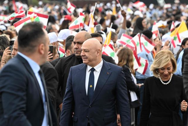 Lebanon's President Joseph Aoun (C) and his wife Nehmat Aoun (R) arrive to attend Pope Leo XIV delivering the homily during a mass at Beirut's waterfront on December 2, 2025. The pontiff arrived from Turkey on November 30, on his inaugural visit abroad as Pope and brought a message of hope, particularly to young people in Lebanon, whose faith in their beleaguered country has dwindled. (Photo by JOSEPH EID / AFP)