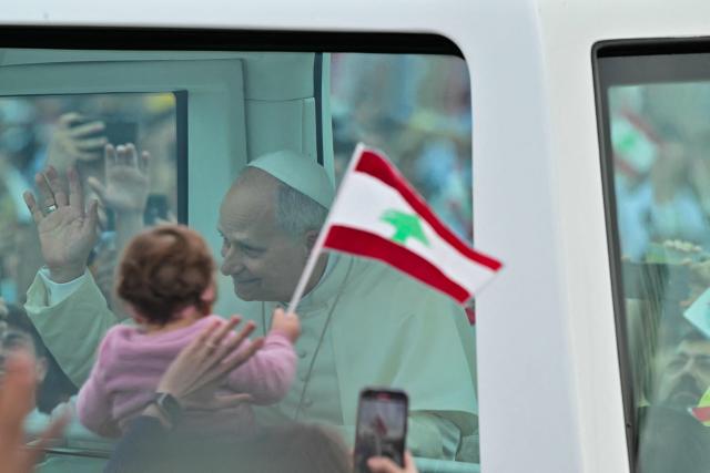 TOPSHOT - Pope Leo XIV waves to faithfuls as he arrives in the popemobile to deliver the homily during a mass at Beirut's waterfront on December 2, 2025. The pontiff arrived from Turkey on November 30, on his inaugural visit abroad as Pope and brought a message of hope, particularly to young people in Lebanon, whose faith in their beleaguered country has dwindled. (Photo by Giuseppe CACACE / AFP)