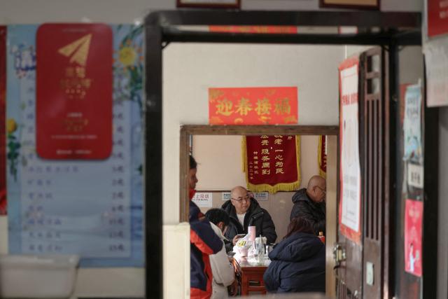 People gather for a meal at a restaurant in Beijing on December 2, 2025. (Photo by Ludovic MARIN / AFP)