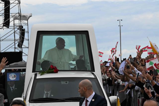 Pope Leo XIV looks at faithfuls as he arrives in the popemobile to deliver a mass at Beirut's waterfront on December 2, 2025. Thousands of Lebanese faithful were making their way to Beirut's waterfront ahead of Pope Leo XIV's mass in the morning of December 2, the highlight of the Catholic leader's visit to the capital expected to draw huge crowds. (Photo by JOSEPH EID / AFP)