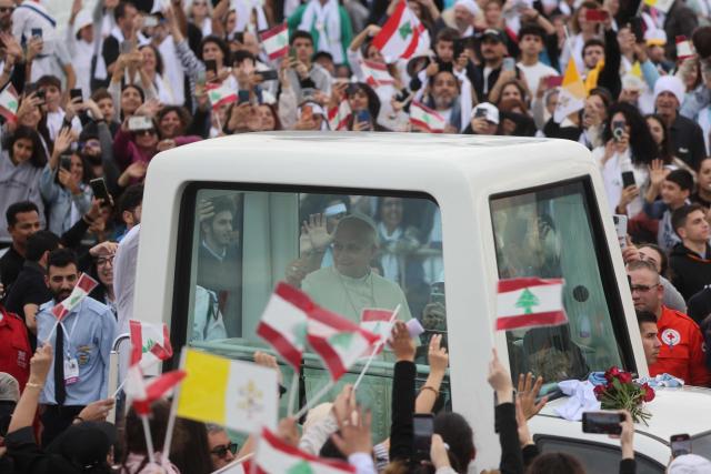 Pope Leo XIV waves to faithfuls as he arrives in the popemobile to deliver a mass at Beirut's waterfront on December 2, 2025. The pontiff arrived from Turkey on November 30, on his inaugural visit abroad as Pope and brought a message of hope, particularly to young people in Lebanon, whose faith in their beleaguered country has dwindled. (Photo by ANWAR AMRO / AFP)