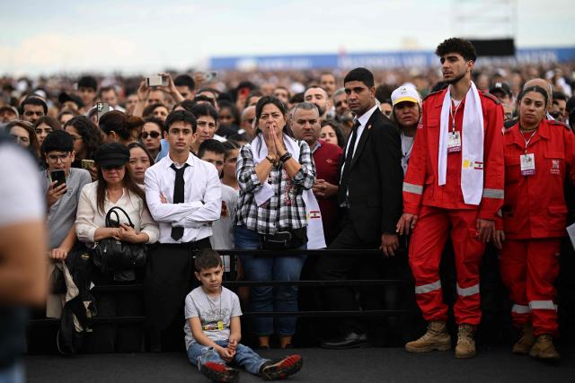 Faithfuls wait for the mass led by Pope Leo XIV to begin at Beirut's waterfront on December 2, 2025. Thousands of Lebanese faithful were making their way to Beirut's waterfront ahead of Pope Leo XIV's mass in the morning of December 2, the highlight of the Catholic leader's visit to the capital expected to draw huge crowds. (Photo by Jewel SAMAD / AFP)