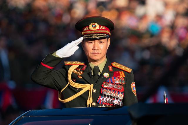Laos' Defence Minister Khamlieng Outhakaisone salutes as he takes part in the Lao National Day military parade on That Luang Esplanade next to the Lao National Assembly in Vientiane on December 2, 2025, during commemorations of 50 years of communist rule.  (Photo by AFP)