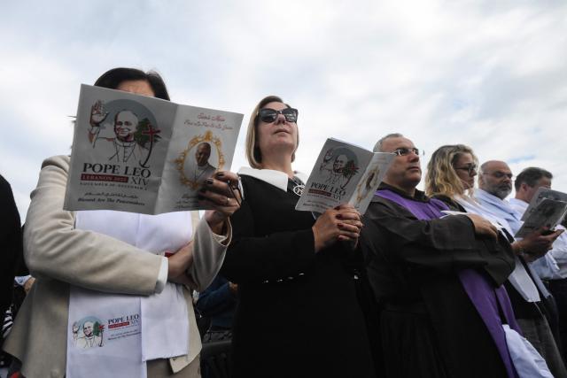 Faithfuls attend a mass led by Pope Leo XIV at Beirut's waterfront on December 2, 2025. Tens of thousands of people gathered at Beirut's waterfront as Pope Leo XIV held mass in the morning of December 2, the highlight of the Catholic leader's visit to the capital. (Photo by Jewel SAMAD / AFP)