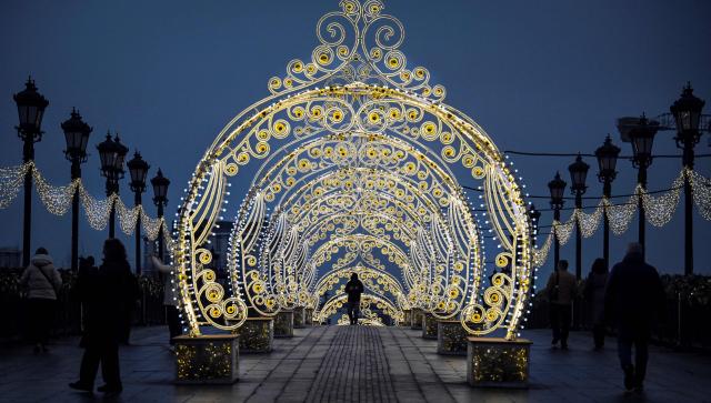 People walk through the Christmas decoration in central Moscow on December 2, 2025, in preparation for the New Year and Christmas holidays. (Photo by Alexander NEMENOV / AFP)