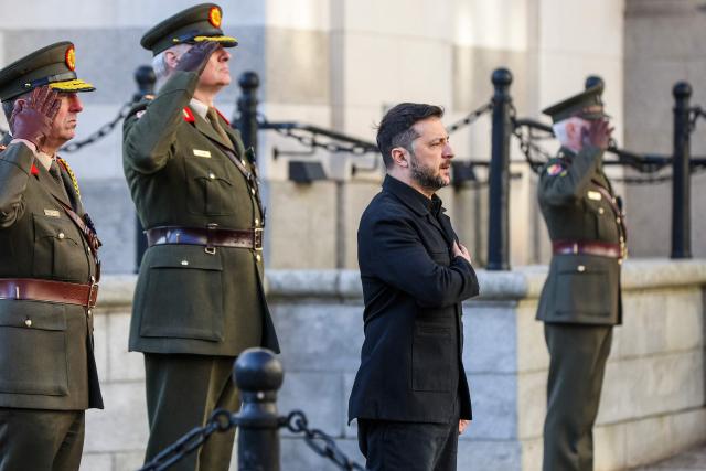 Ukraine's President Volodymyr Zelensky (2nd R) listen's to his country's national anthem upon his arrival at the government buildings in Dublin on December 2, 2025. (Photo by Paul Faith / AFP)