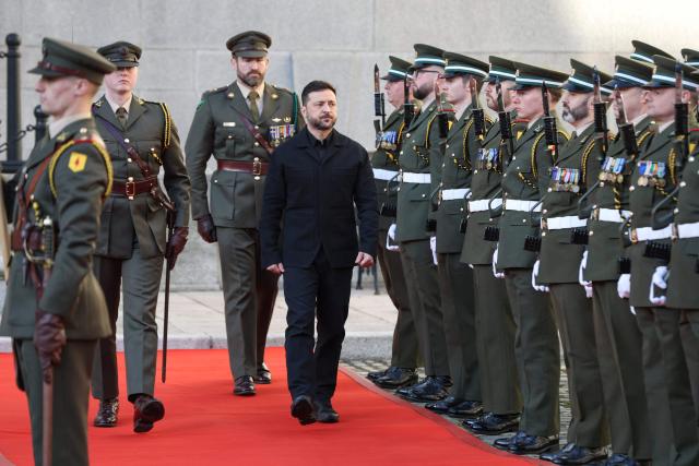 Ukraine's President Volodymyr Zelensky (C) inspects a guard of honour on arrival at the government buildings on his first official visit in Dublin on December 2, 2025. (Photo by Paul Faith / AFP)