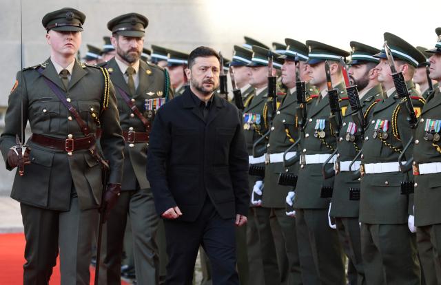 Ukraine's President Volodymyr Zelensky (C) inspects a guard of honour on arrival at the government buildings on his first official visit in Dublin on December 2, 2025. (Photo by Paul Faith / AFP)