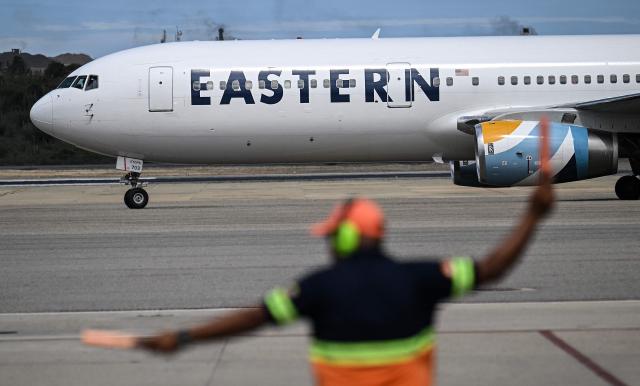 (FILES) An Eastern Airlines plane carrying Venezuelan migrants repatriated from the United States lands at Simon Bolivar International Airport in Maiquetia, Venezuela, on November 26, 2025. Venezuela announced on December 2, 2025, that it had reauthorized flights carrying migrants deported by the United States, days after suspending them due to President Donald Trump's demand that Venezuelan airspace be considered "closed." (Photo by Juan BARRETO / AFP)