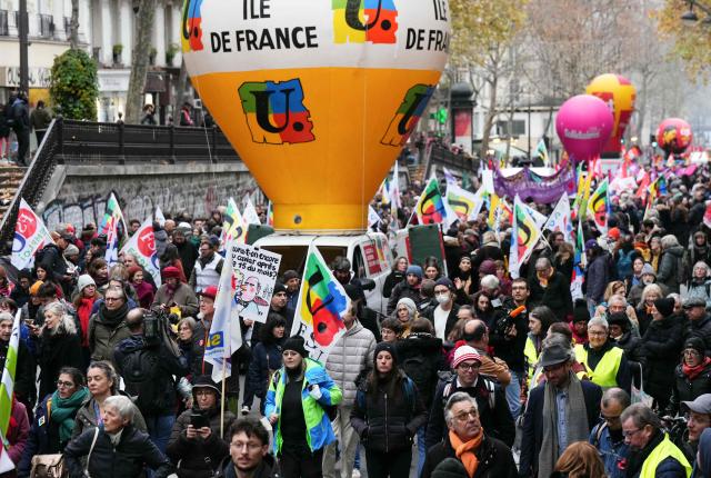 Protesters take part in a demonstration as part of a call by trade unions for strikes and demonstrations for higher wages and against austerity, in Paris on December 2, 2025. (Photo by Dimitar DILKOFF / AFP)