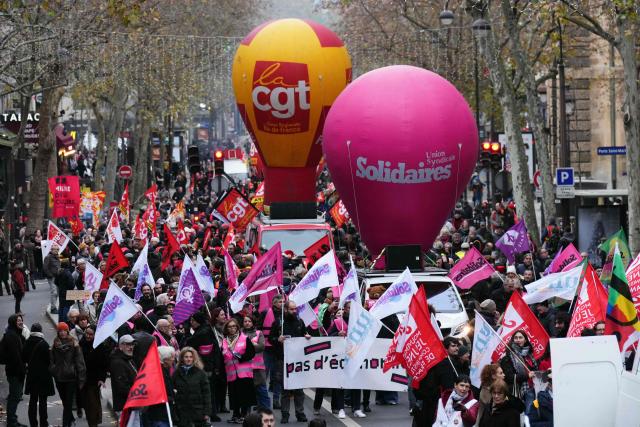 Protesters take part in a demonstration as part of a call by trade unions for strikes and demonstrations for higher wages and against austerity, in Paris on December 2, 2025. (Photo by Dimitar DILKOFF / AFP)