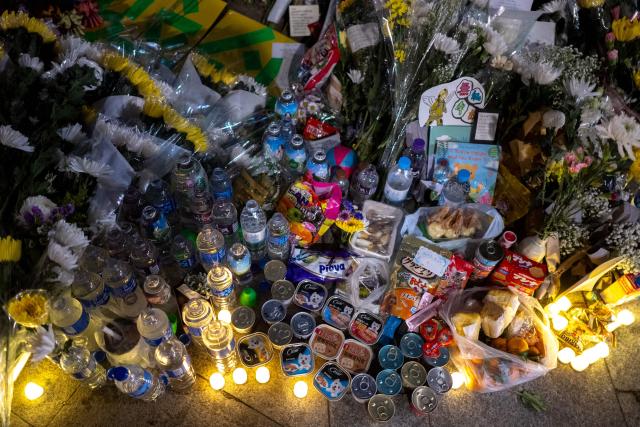 Flowers and food are offered during a vigil held outside the Wang Fuk Court apartment blocks in the aftermath of the deadly November 26 fire in Hong Kong's Tai Po district on December 2, 2025. Hong Kong's leader said on December 2 that an independent committee will investigate the causes of the city's deadliest fire in decades, after authorities found substandard building materials had accelerated the blaze. The fire engulfed seven residential towers under renovation in the north of the city last week, killing at least 156 people, displacing thousands more and fuelling public demands for accountability. (Photo by Philip FONG / AFP)