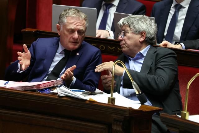 Droite Republicaine's MP and rapporteur of the 'commission mixte paritaire' (CMP) for the end-of-end-year budget Philippe Juvin (L) speaks with La France Insoumise - Nouveau Front Populaire's MP and vice-president of the 'commission mixte paritaire' (CMP) Eric Coquerel during the debate on the budget bill for the 2025 end-year at the National Assembly, the French Parliament lower house, in Paris on December 2, 2025. (Photo by Thomas SAMSON / AFP)