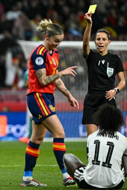 Italian referee Silvia Gasperotti (R) shows a yellow card to Spain's defender #16 Mapi Leon (L) during the UEFA Women's Nations League second leg final football match between Spain and Germany at the Metropolitano Stadium in Madrid on December 2, 2025. (Photo by Javier SORIANO / AFP)