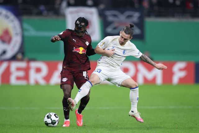 Leipzig's Ivorian forward #49 Yan Diomande (L) and Magdeburg's German forward #23 Baris Atik vie for the ball during the German Cup (DFB-Pokal) round of 16 football match between RB Leipzig and 1 FC Magdeburg in Leipzig, eastern Germany on December 2, 2025. (Photo by Ronny HARTMANN / AFP) / DFB REGULATIONS PROHIBIT ANY USE OF PHOTOGRAPHS AS IMAGE SEQUENCES AND QUASI-VIDEO.