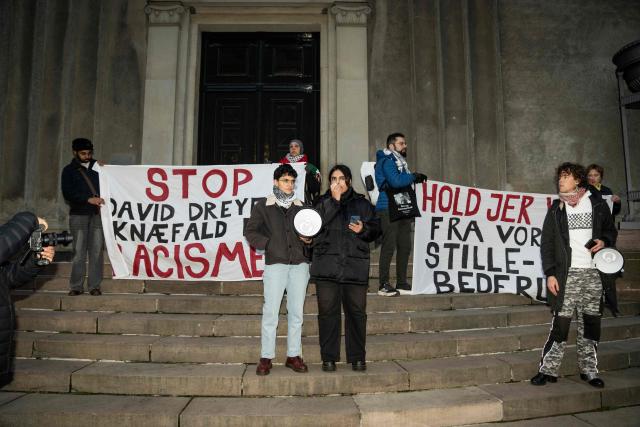 Participants display banners reading 'Stop David Dreyer's kneeling for racism' (L) and 'Stay away from our quiet and prayerful place' during a demonstration against the closure of quiet rooms at the KU, University of Copenhagen, in front of the Rectorate at Frue Plads in Copenhagen on December 2, 2025. A group of students is demonstrating against the closure of the quiet rooms. The rooms have been controversial as particularly Muslim students have benefited from them, but the criticism has been that they have been used for the control of particularly female Muslim students. David Dreyer Lassen is the rector of the University of Copenhagen. (Photo by Sebastian Elias Uth / Ritzau Scanpix / AFP) / Denmark OUT