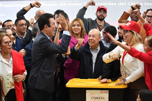 Salvador Nasralla (2nd L), presidential candidate for the opposition Liberal Party, celebrates with his main collaborators next to boxes containing electoral tally sheets during a press conference in Tegucigalpa on December 2, 2025. Honduras' electoral authority, under pressure from US President Donald Trump, said on December 2 that the results of the presidential elections in Honduras will be "scrupulously" respected, where right-wing candidates Nasry Asfura and Salvador Nasralla are in a technical tie. (Photo by Orlando SIERRA / AFP)
